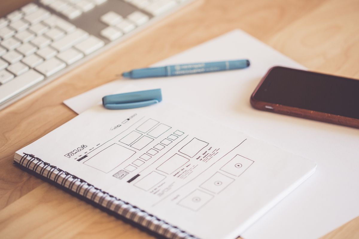 UI design wireframes with smartphone and keyboard on desk