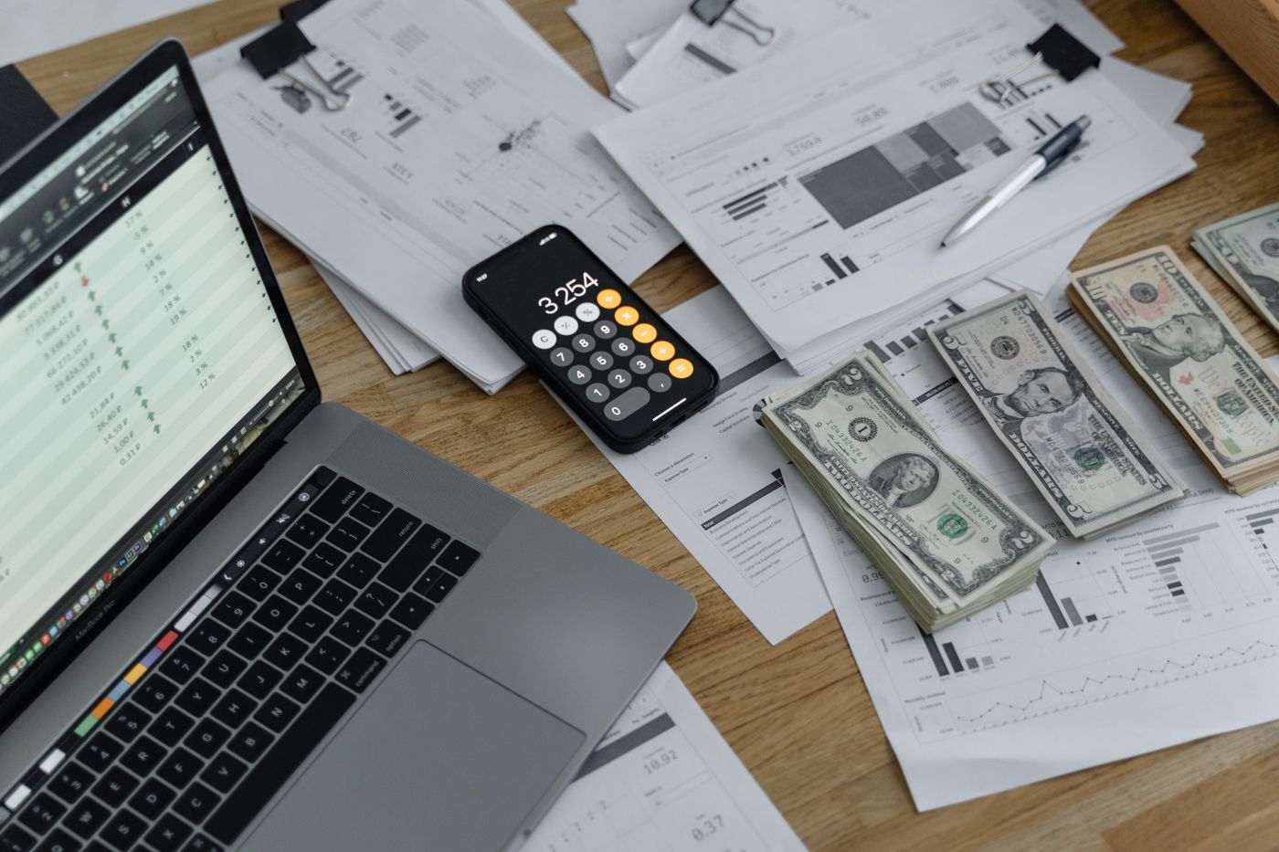 Payroll documents, calculator and laptop on an office desk